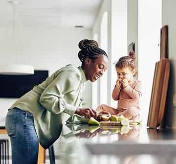 Mom and child eating healthy snack in kitchen